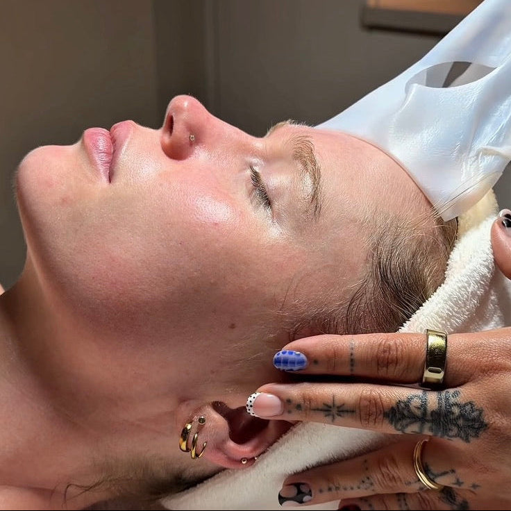 Person receiving a facial treatment with a hand applying product.