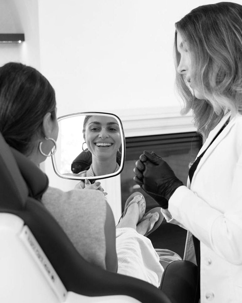 Woman getting a pedicure with a reflection in a mirror.