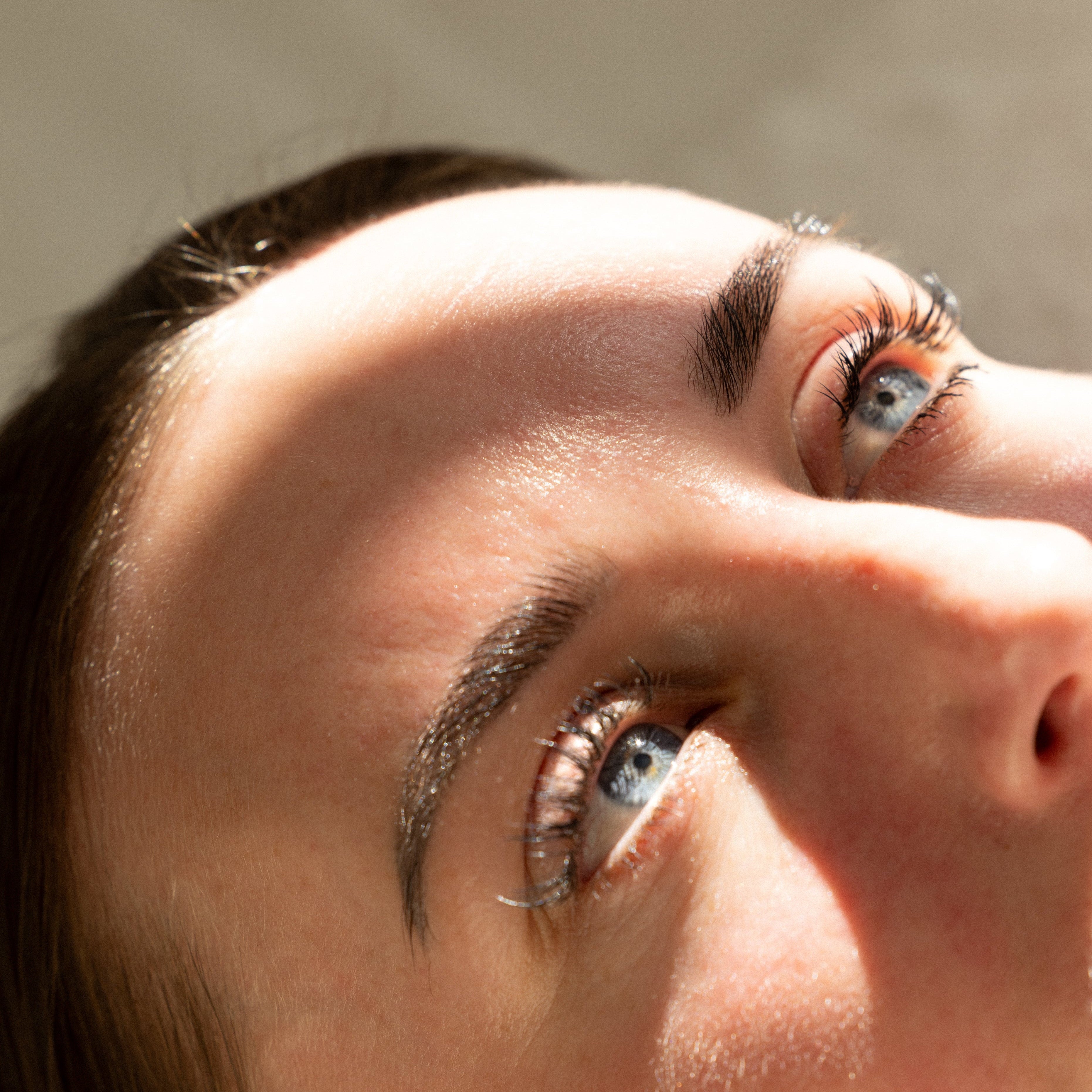 Close-up of a person's eyes looking upwards with a neutral background at a medical aesthetic services place in philadelphia.