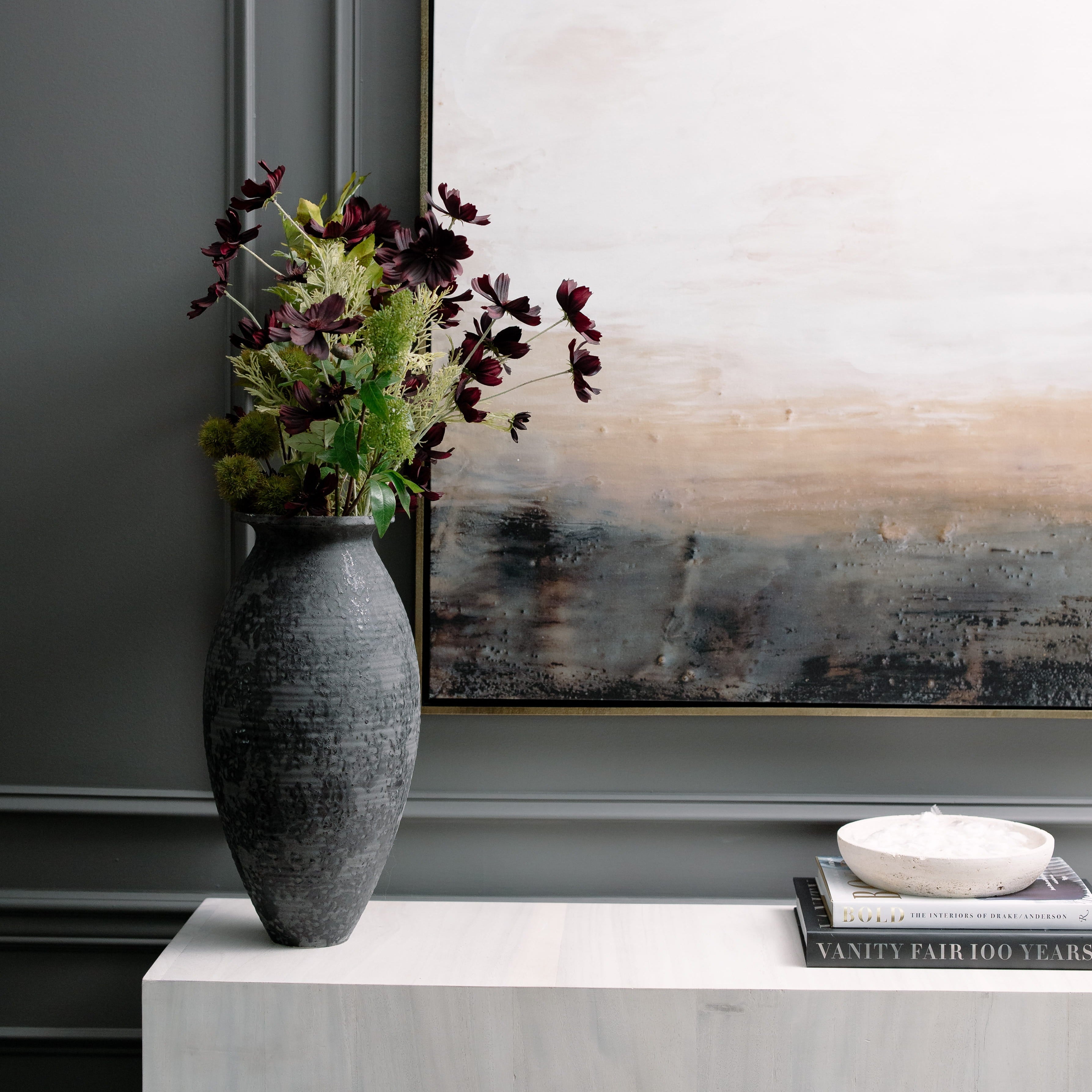 Decorative vase with flowers at skndustry philadelphia on a white surface in front of abstract art
